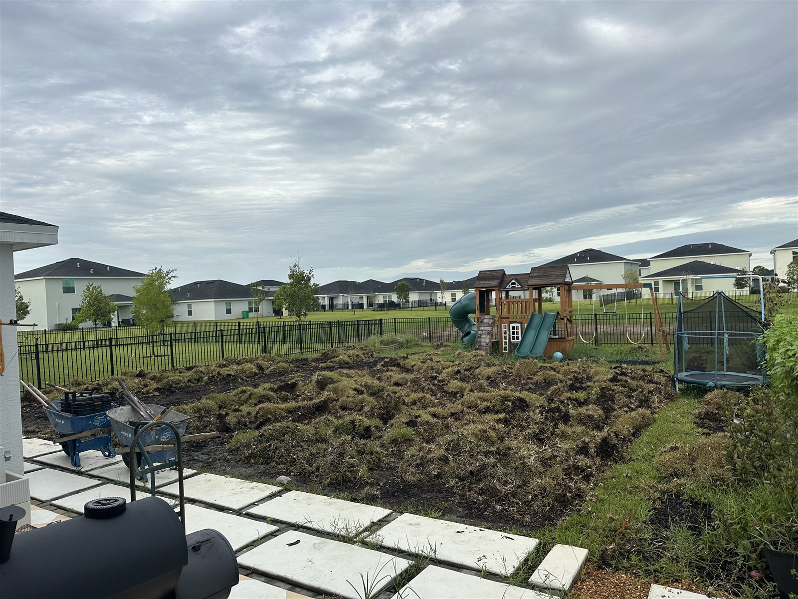 Turf installation, photo 1 of 4: existing lawn being removed around a backyard play area