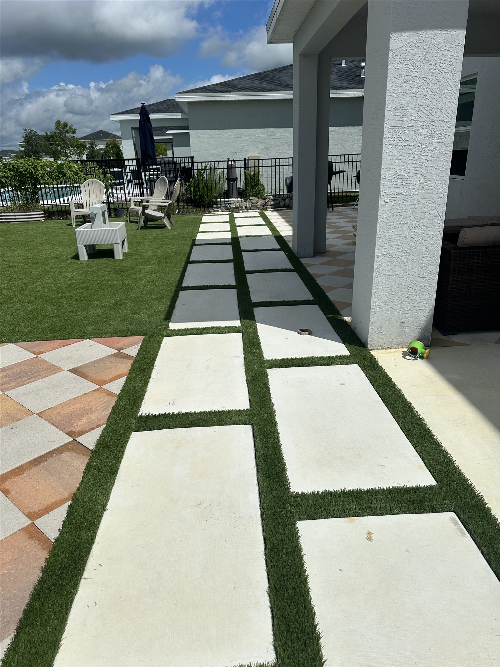 Turf installation, photo 3 of 4: installed turf fitted around a white stepping-stone walkway